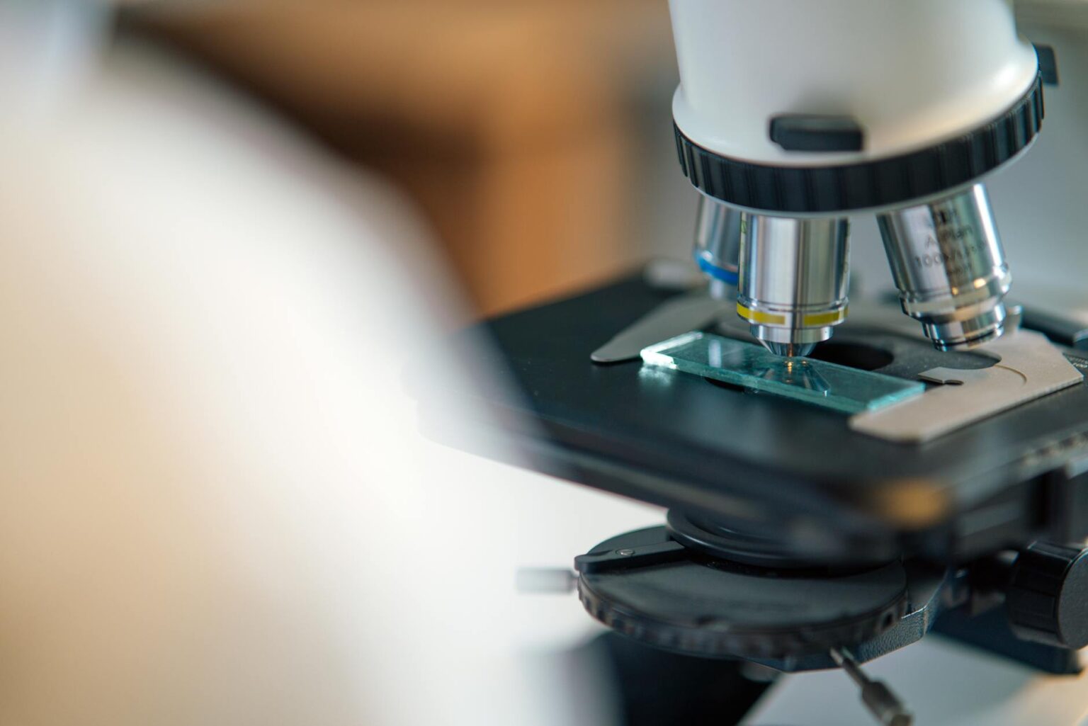 Close-up view of smartphone with microscope attachment examining a specimen