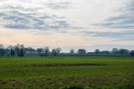 Person holding smartphone in rural mountainous landscape searching for cellular signal