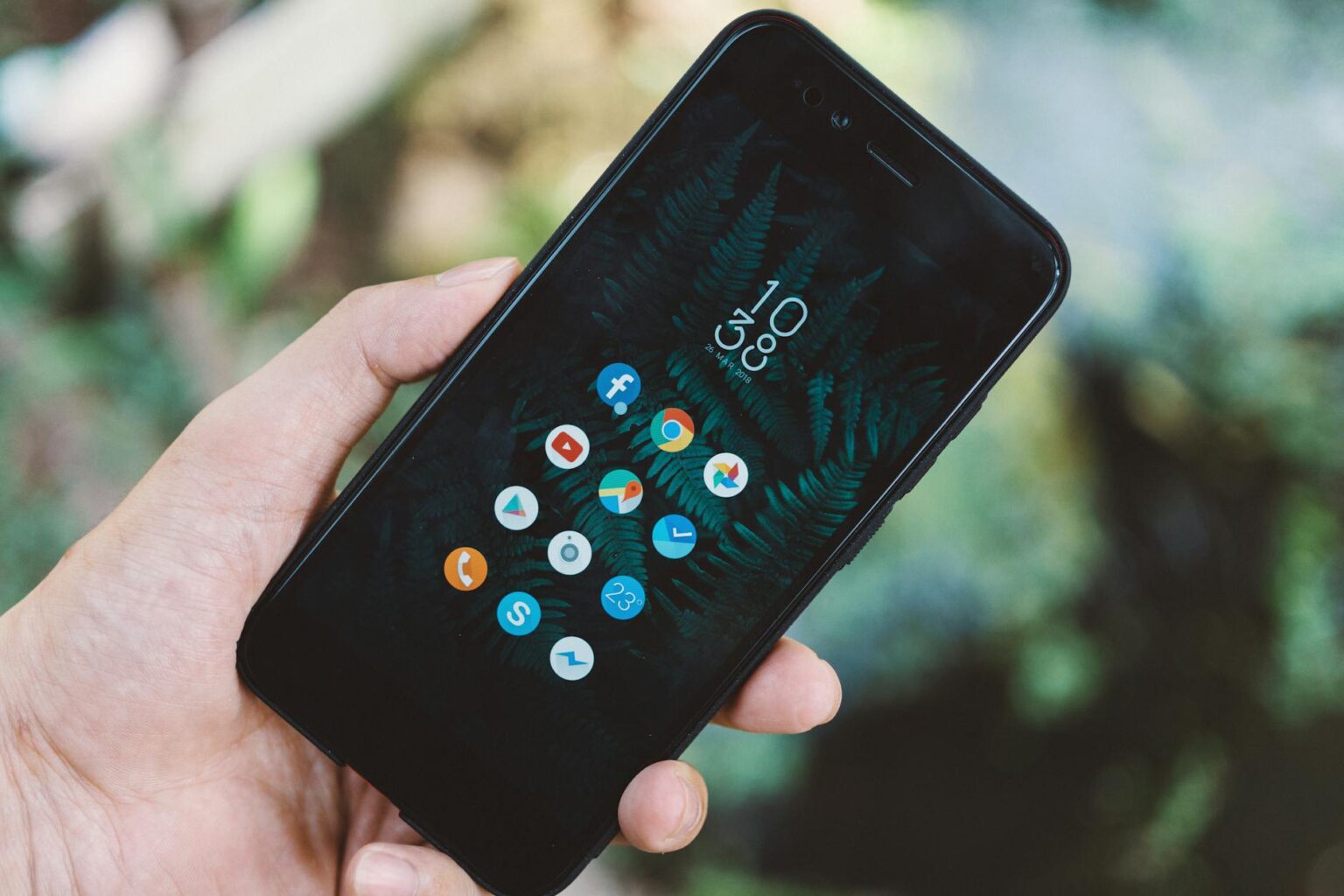Why Smartphone Manufacturers Are Adding Dedicated Camera Buttons Again Person holding smartphone taking a photo with finger on screen