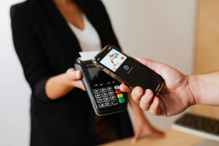Person using smartphone for contactless payment at retail terminal