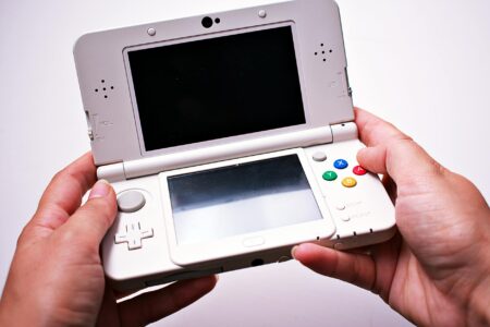 How Valve’s Steam Deck Success Is Inspiring Nintendo’s Next Console Person holding a portable gaming device with screen displaying a video game