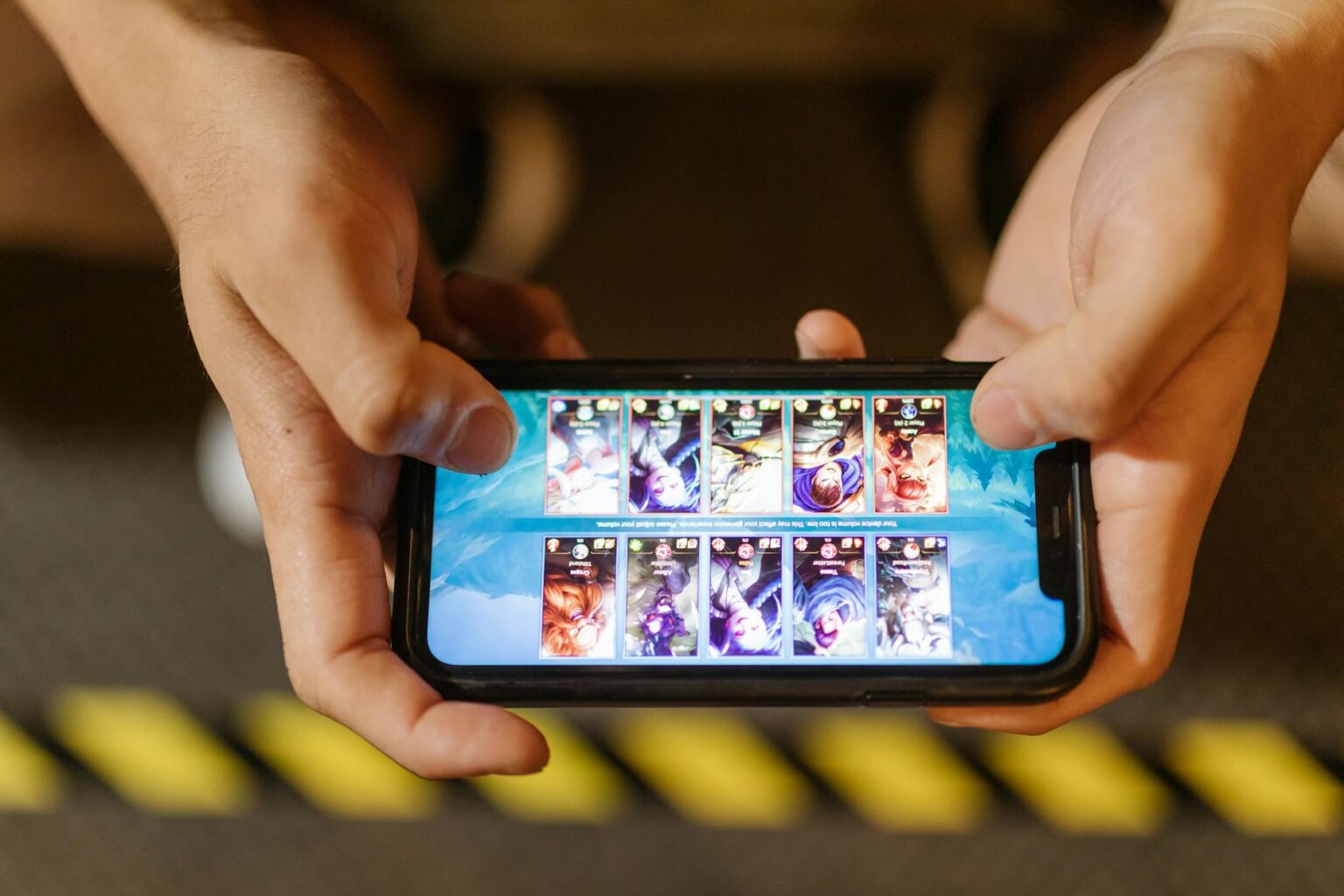 Person playing mobile game on smartphone with vibrant graphics display