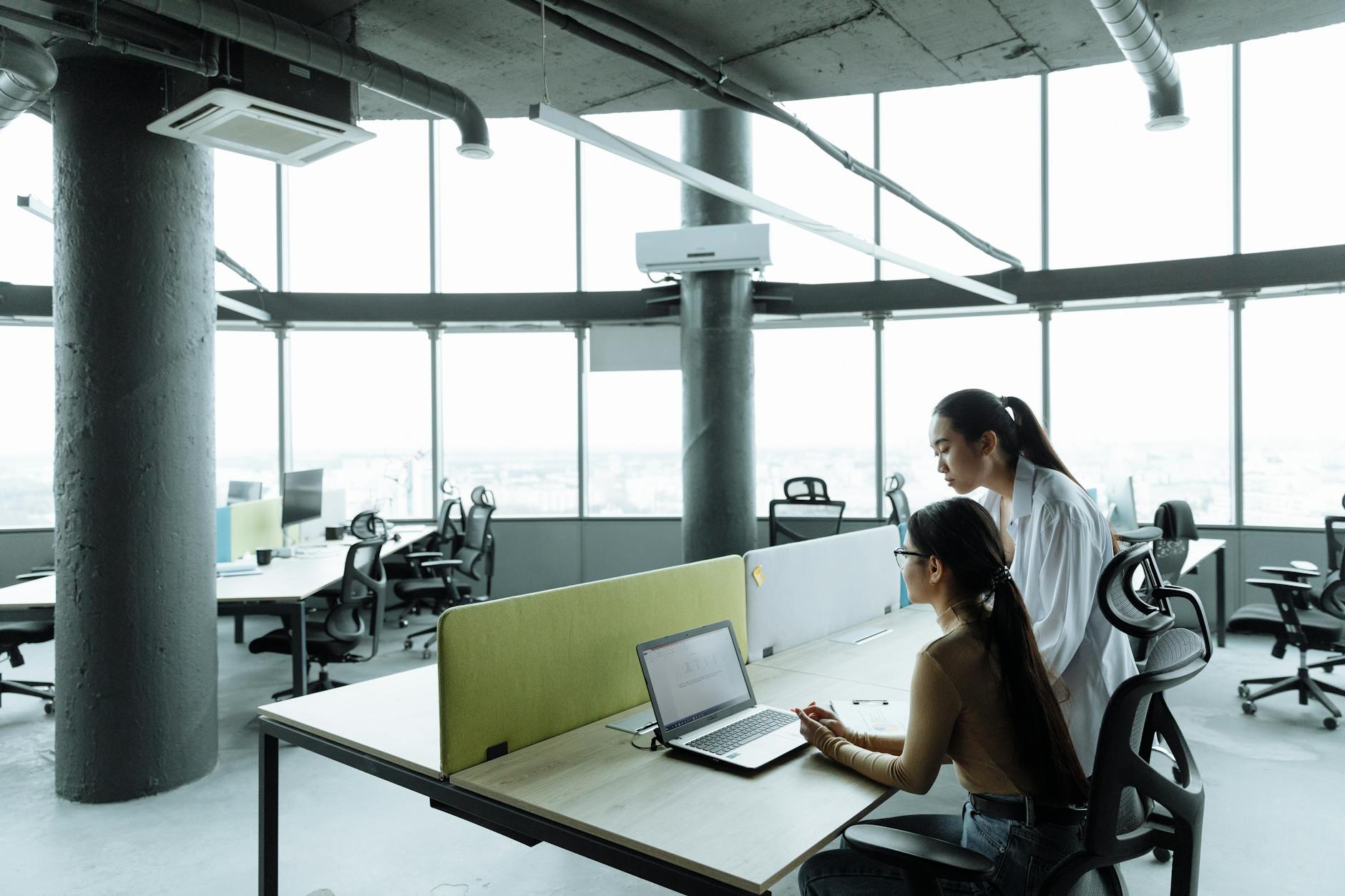 Modern office workspace with multiple people collaborating on computers