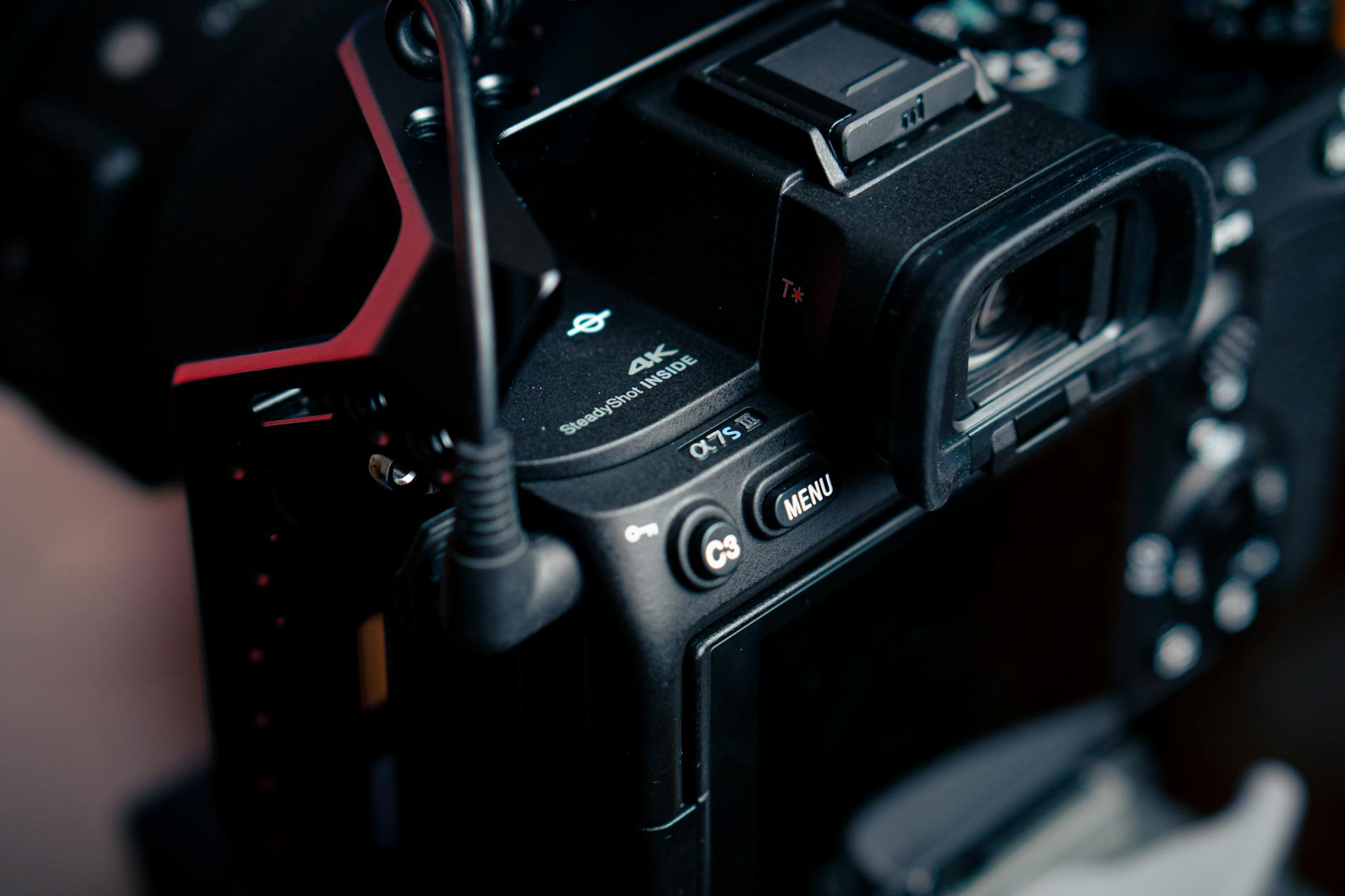 Close-up of finger pressing a physical camera button on electronic device