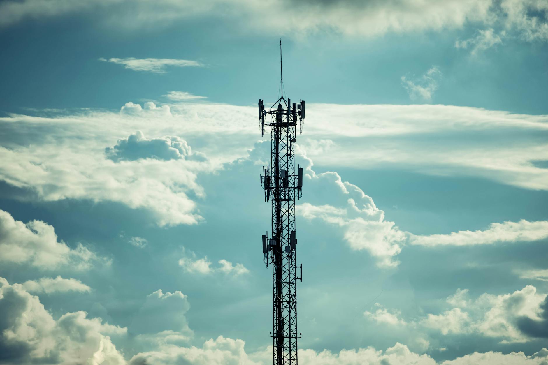 Telecommunications tower with multiple antennas in rural landscape, showing 5G infrastructure deployment