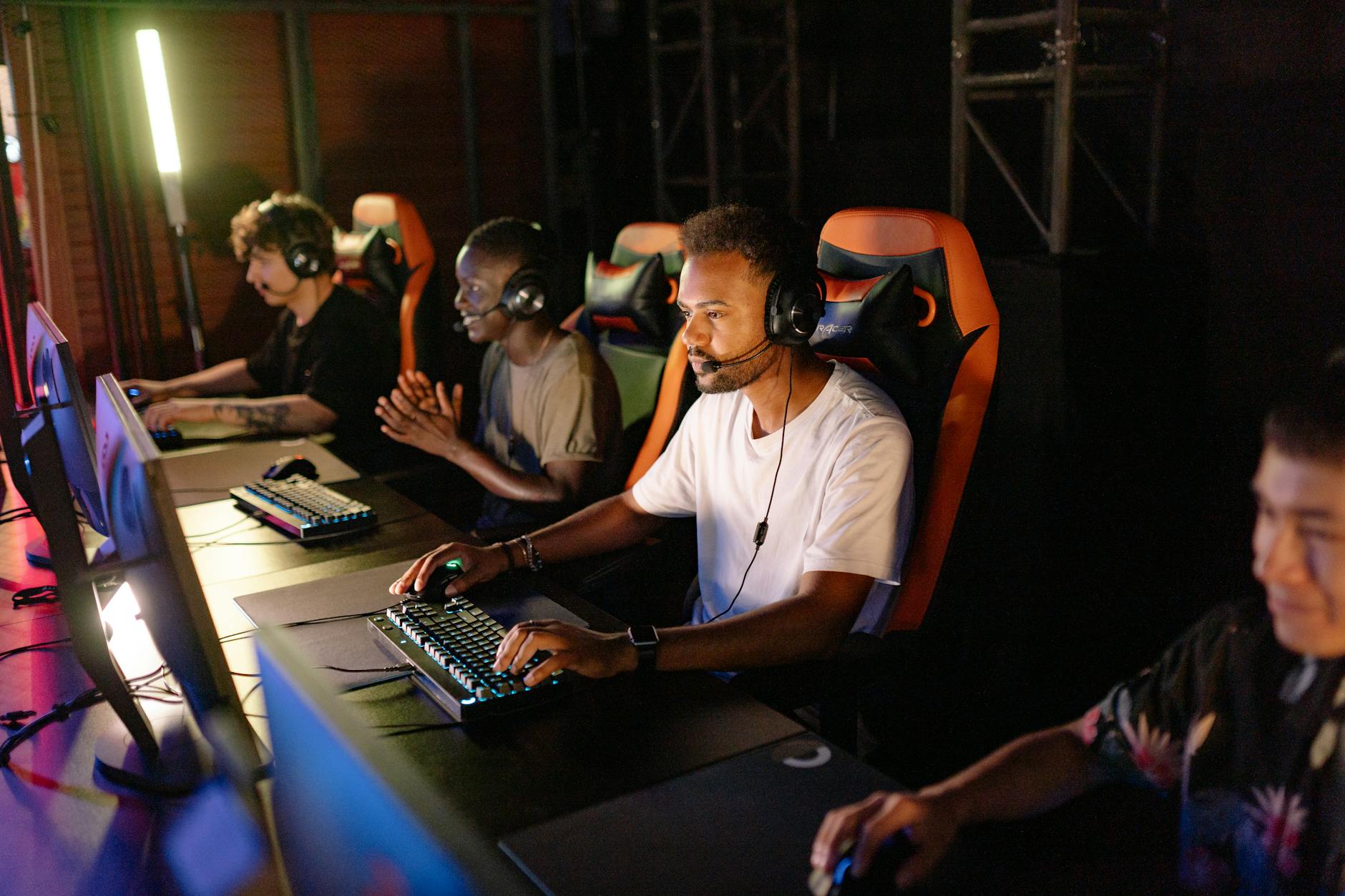 Professional esports tournament setup with multiple high-end gaming monitors and competitive players