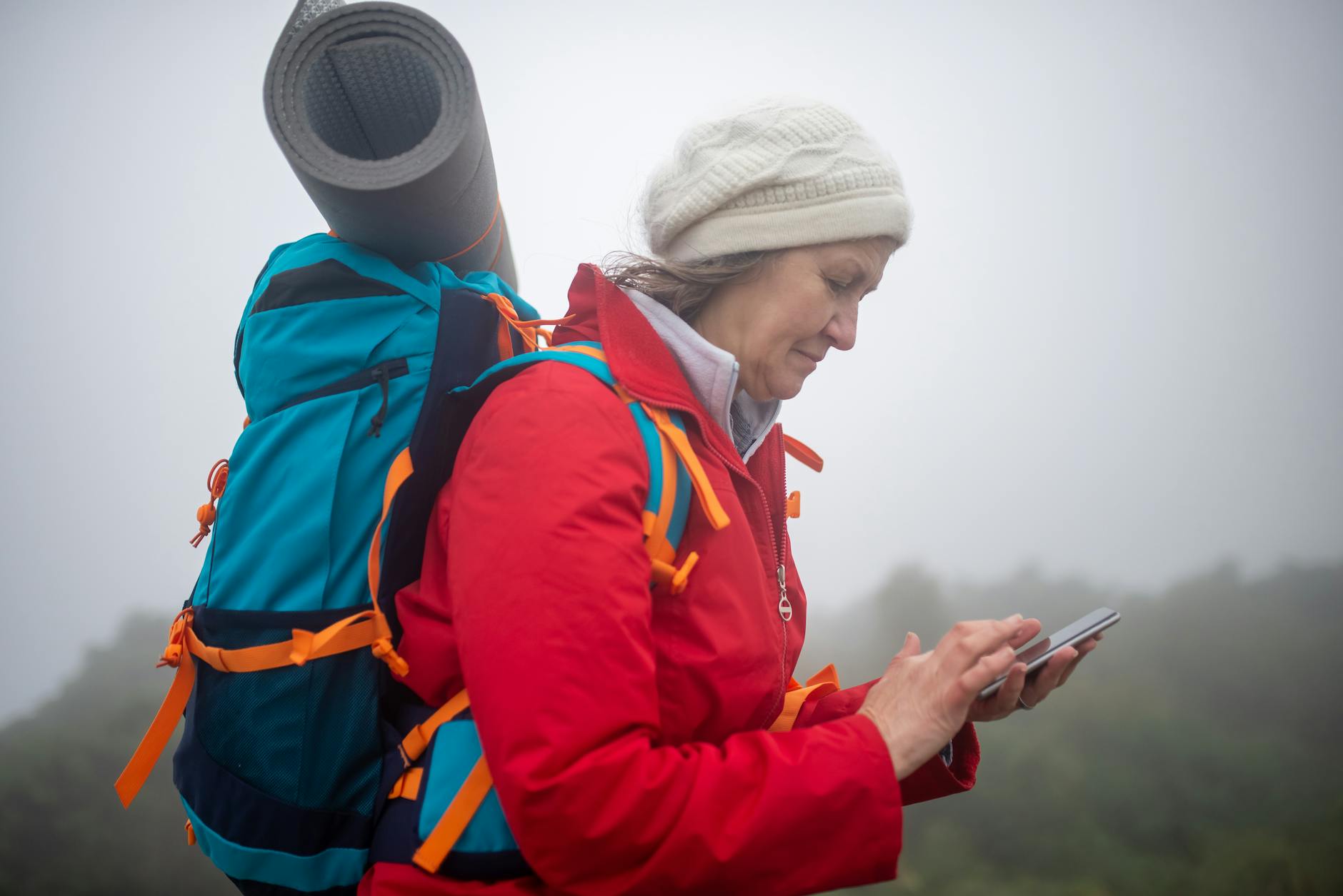 Hiker using smartphone for emergency communication in remote mountain location