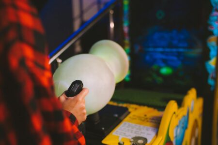 Arcade Fighting Games Are Pulling Competitive Players Back From Battle Royales A classic arcade game cabinet in a dimly lit gaming venue