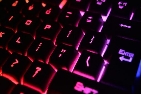 Corsair’s iCUE Software Overhaul Is Winning Back Peripheral Enthusiasts Backlit gaming keyboard on a desk showing RGB lighting effects