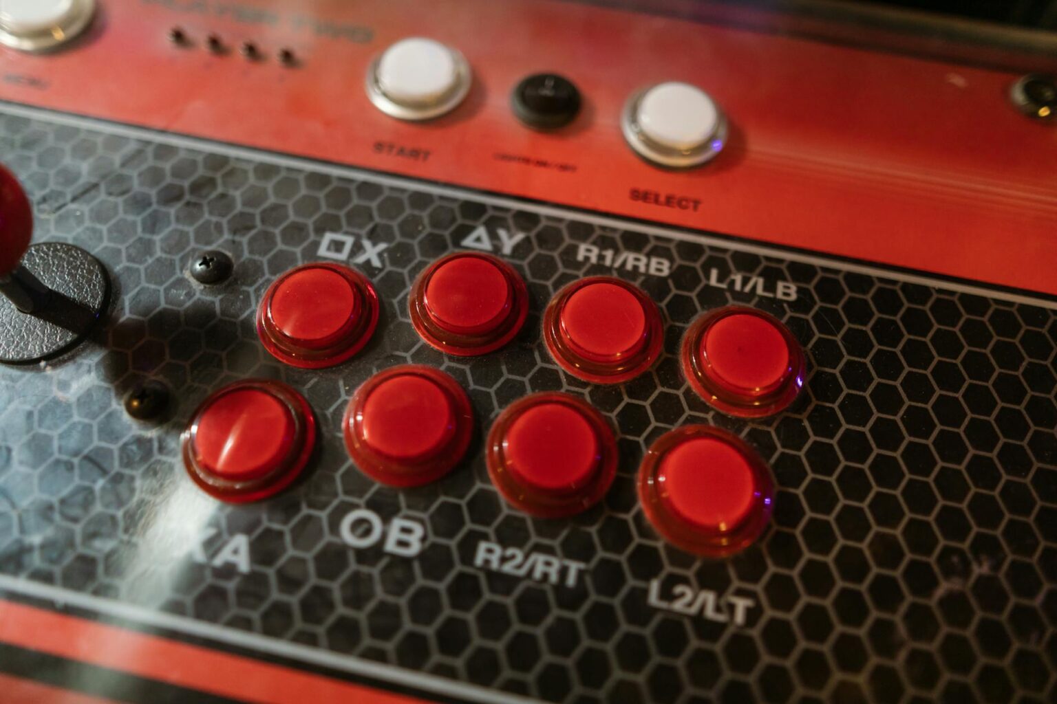 Close-up of a custom arcade stick with colorful buttons and a joystick lever on a desk