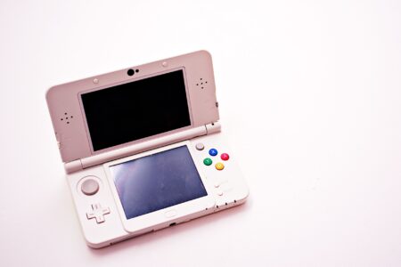 Person holding a handheld gaming console while relaxing on a couch