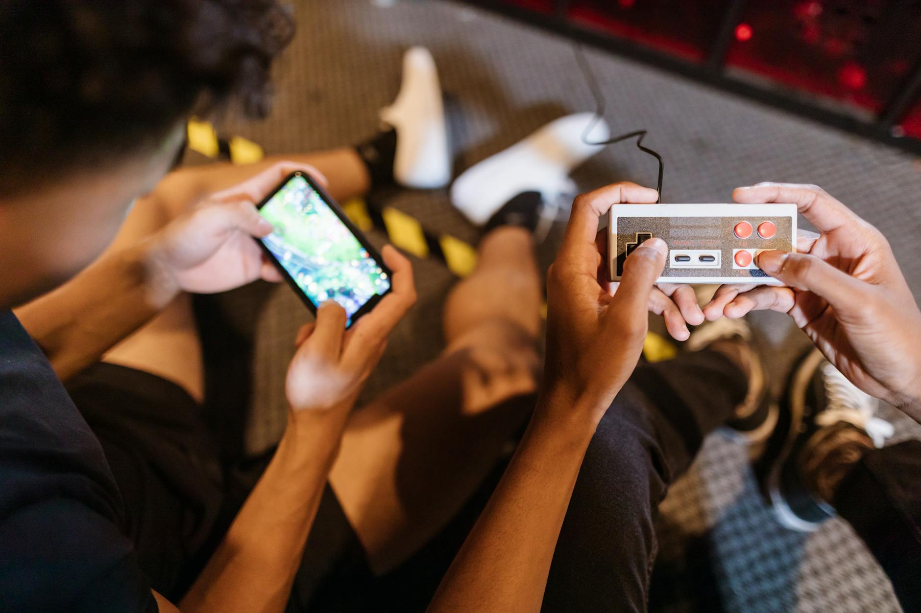 Hands holding smartphone displaying mobile game with colorful graphics on screen