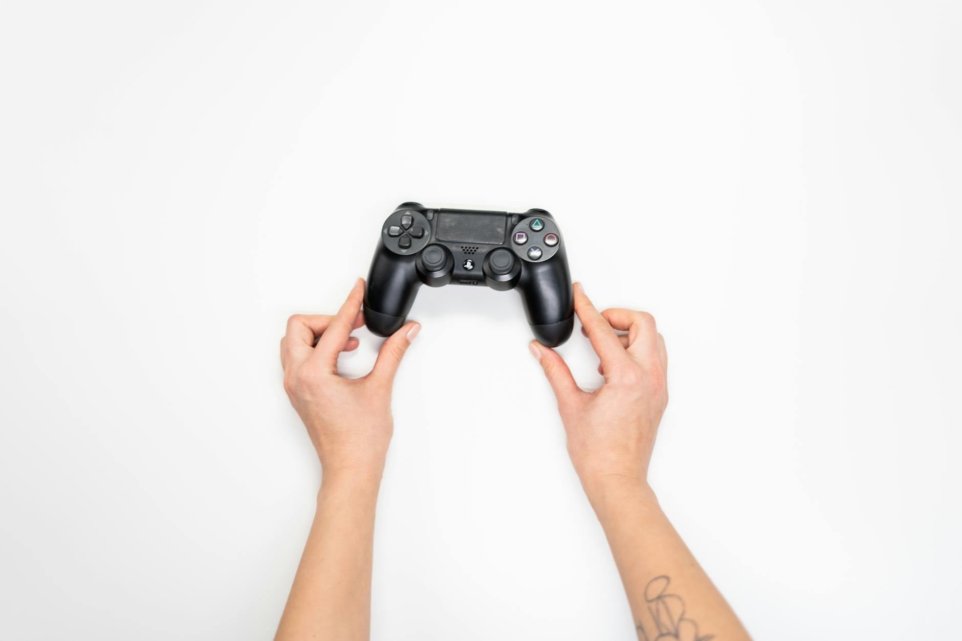 Close-up of a game controller held by a player in a dark gaming environment