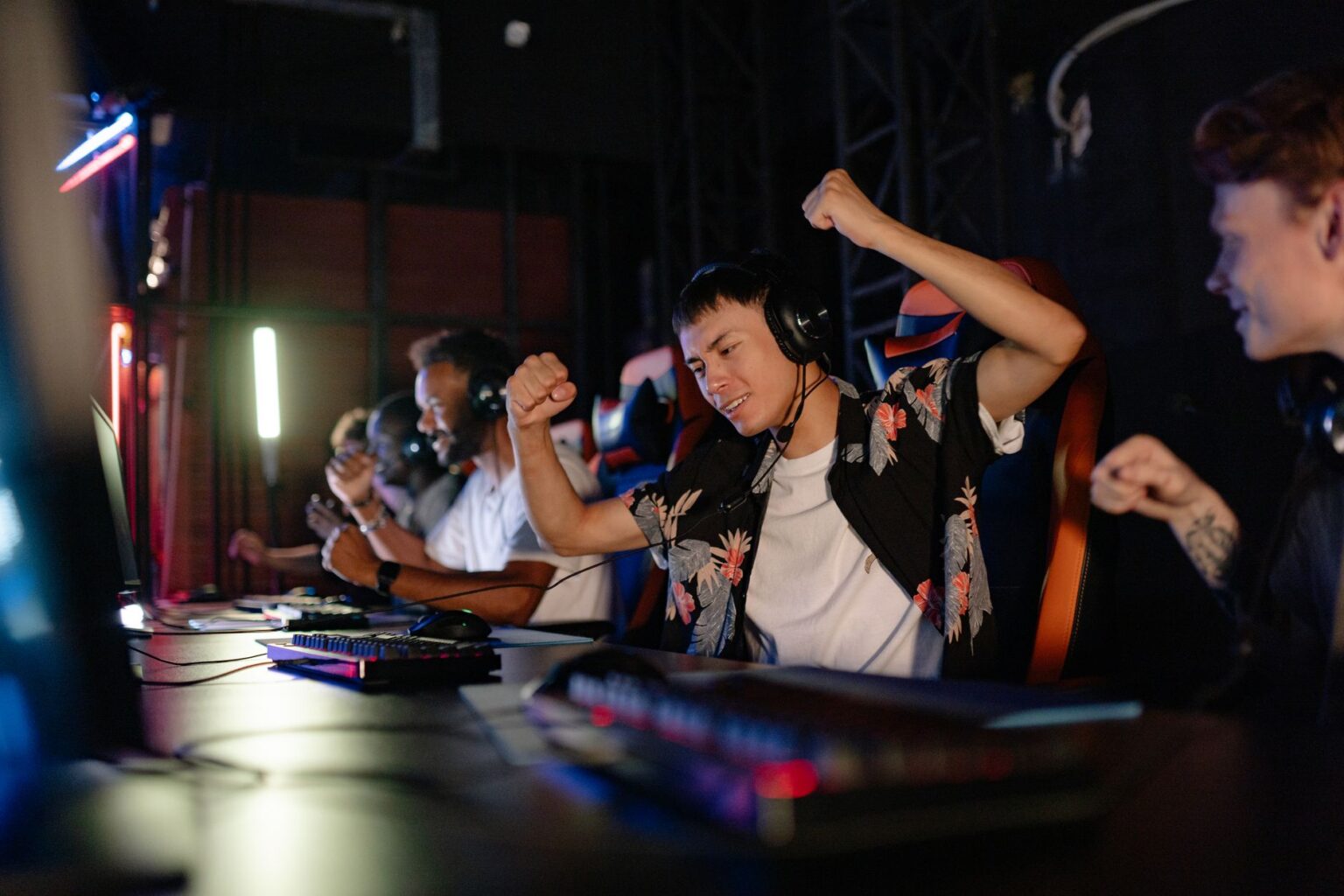 Riot’s League of Legends Veteran Players Are Defecting to Deadlock A dark gaming setup with multiple monitors glowing, representing competitive PC gaming culture