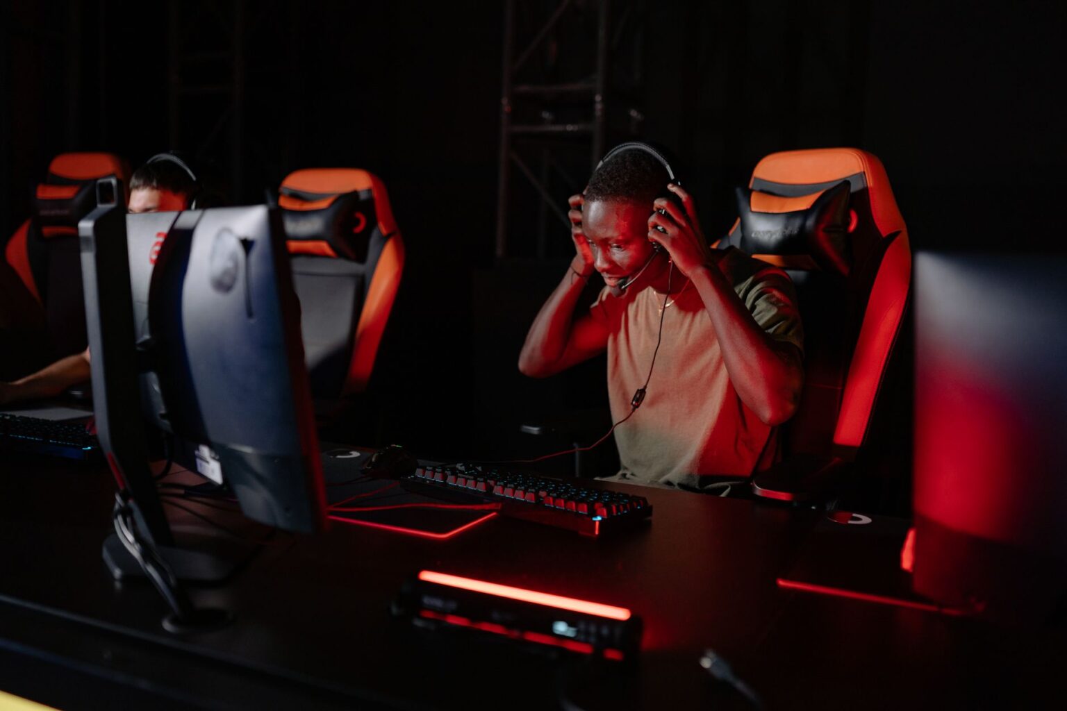 A gaming setup with multiple monitors showing a tactical shooter interface
