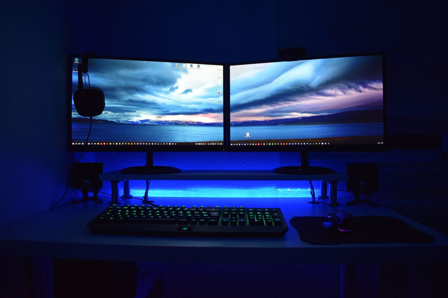 A gaming PC setup with monitor displaying a first-person shooter game