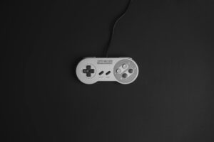 A dark-lit gaming controller resting on a desk, representing the competitive shooter gaming scene