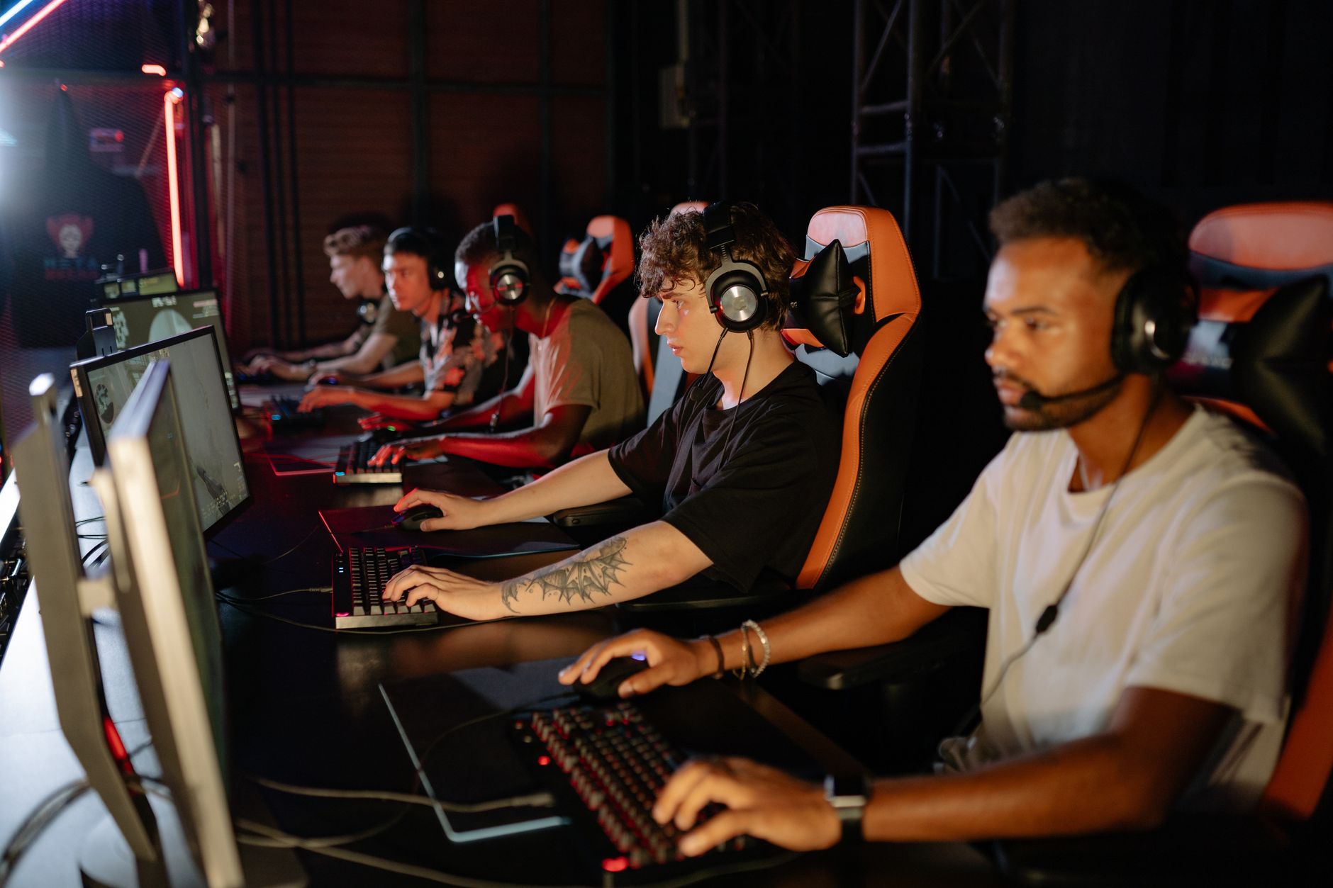 Players competing at an esports tournament event with large screens overhead