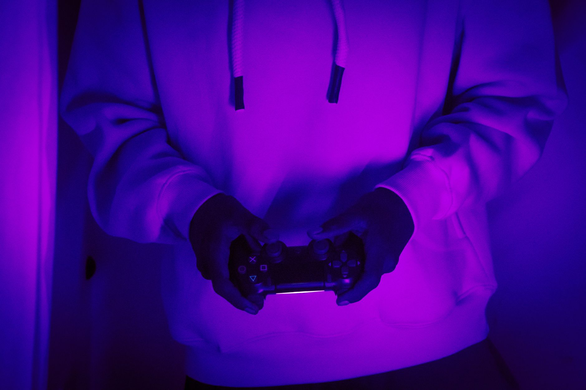 Gaming controller illuminated by neon lighting suggesting retro game aesthetics