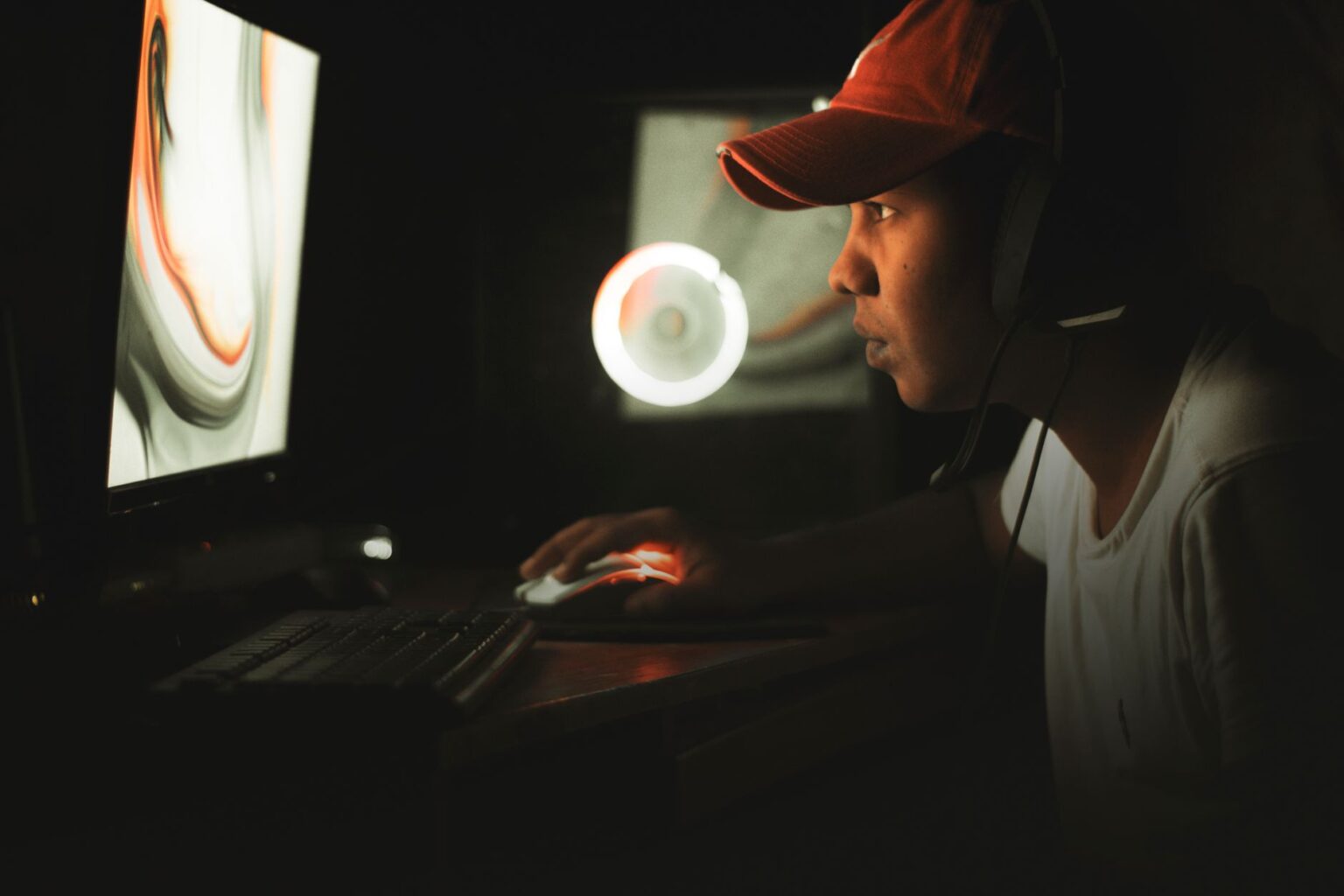 A dark gaming setup with monitor glow, representing a player waiting for game news