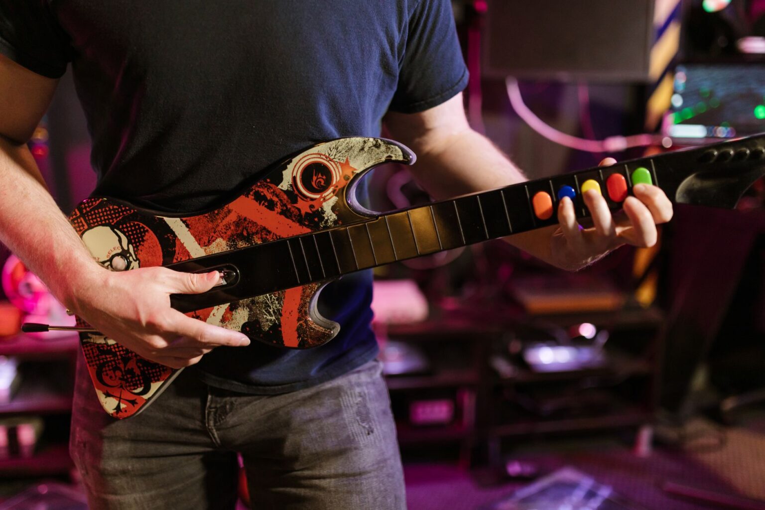 A plastic guitar controller resting on a desk, used for rhythm games like Guitar Hero and Clone Hero