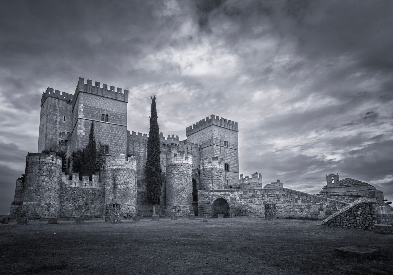 A dark, atmospheric gothic castle surrounded by fog, evoking the visual tone of Resident Evil Village
