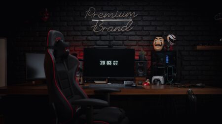 Dark gaming setup with monitor glowing in a dimly lit room