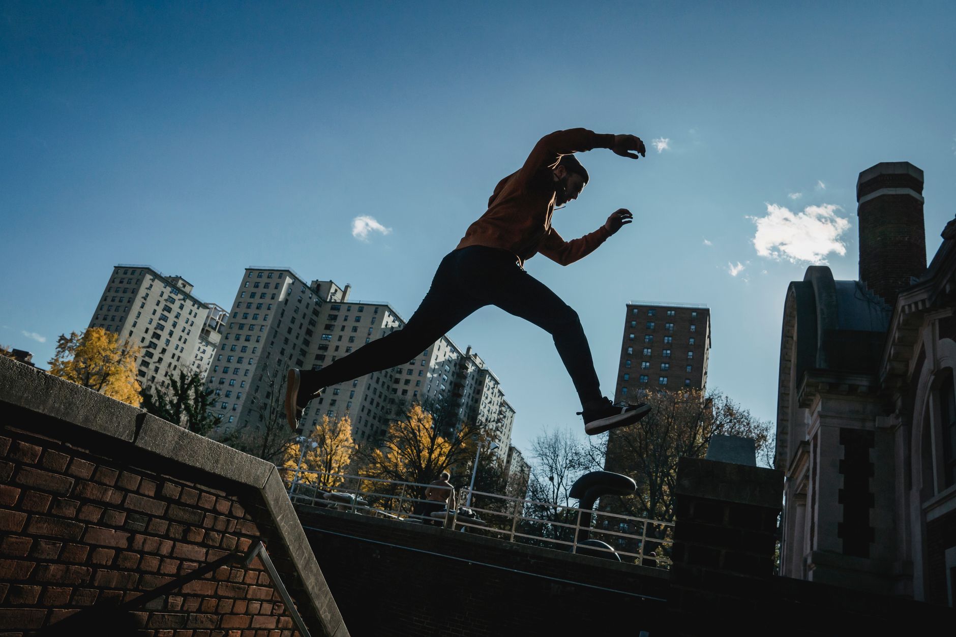 Person performing parkour across rooftops, similar to the movement mechanics in Dying Light 2
