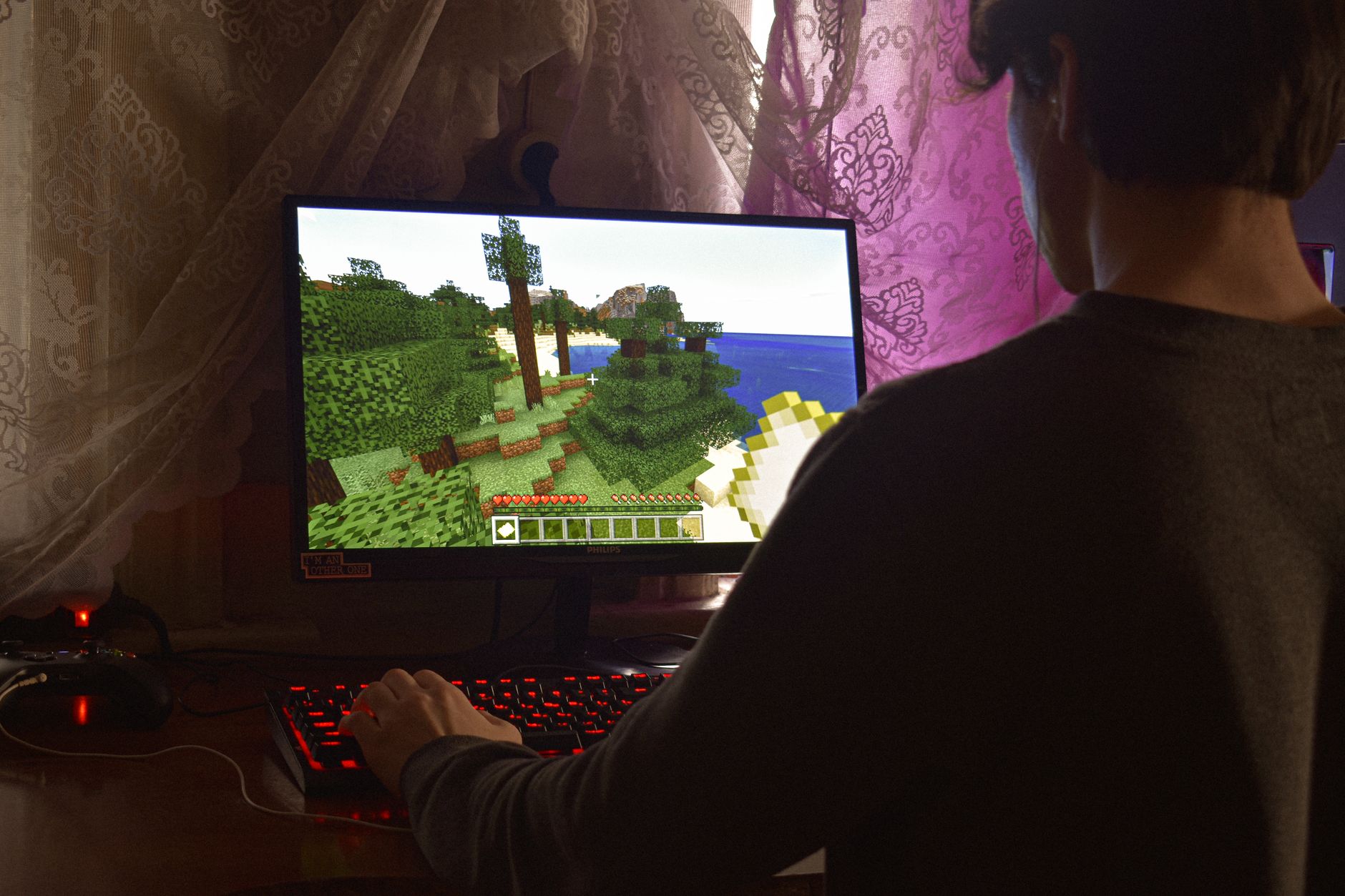 A person playing a video game on a large screen in a dimly lit room