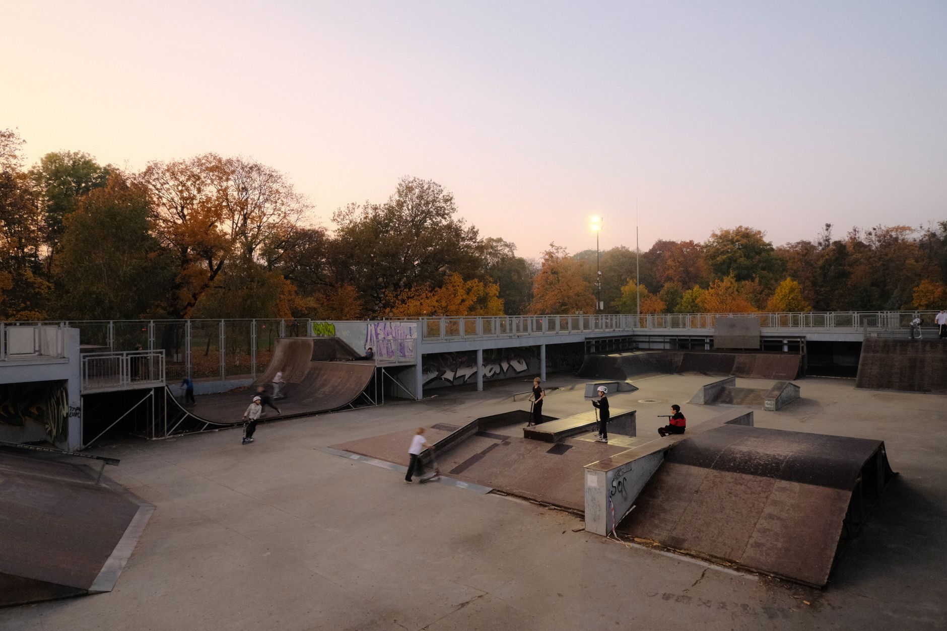 An outdoor urban skate park with concrete ramps and rails on a sunny day