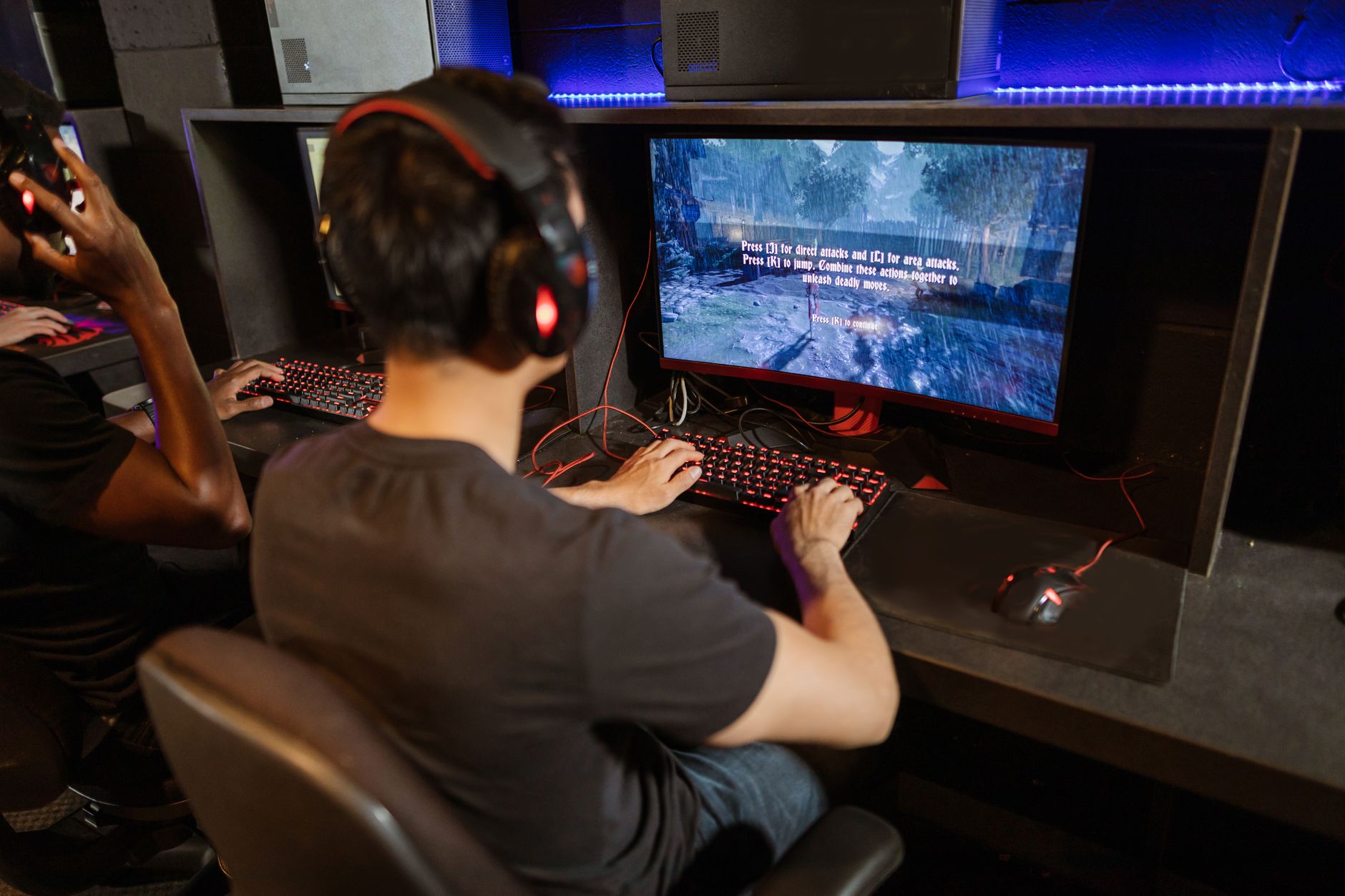 Gamer playing a video game on screen in a darkened room