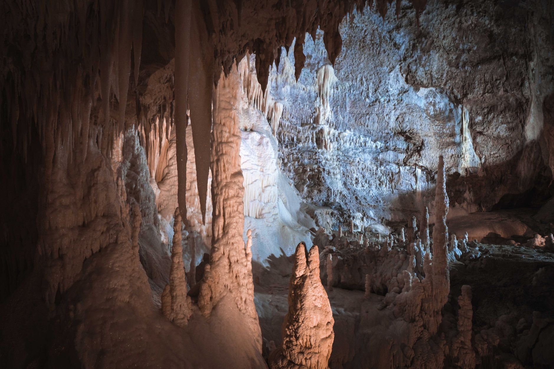 Dark underground cave tunnel with dramatic lighting, evoking Deep Rock Galactic's mining environments