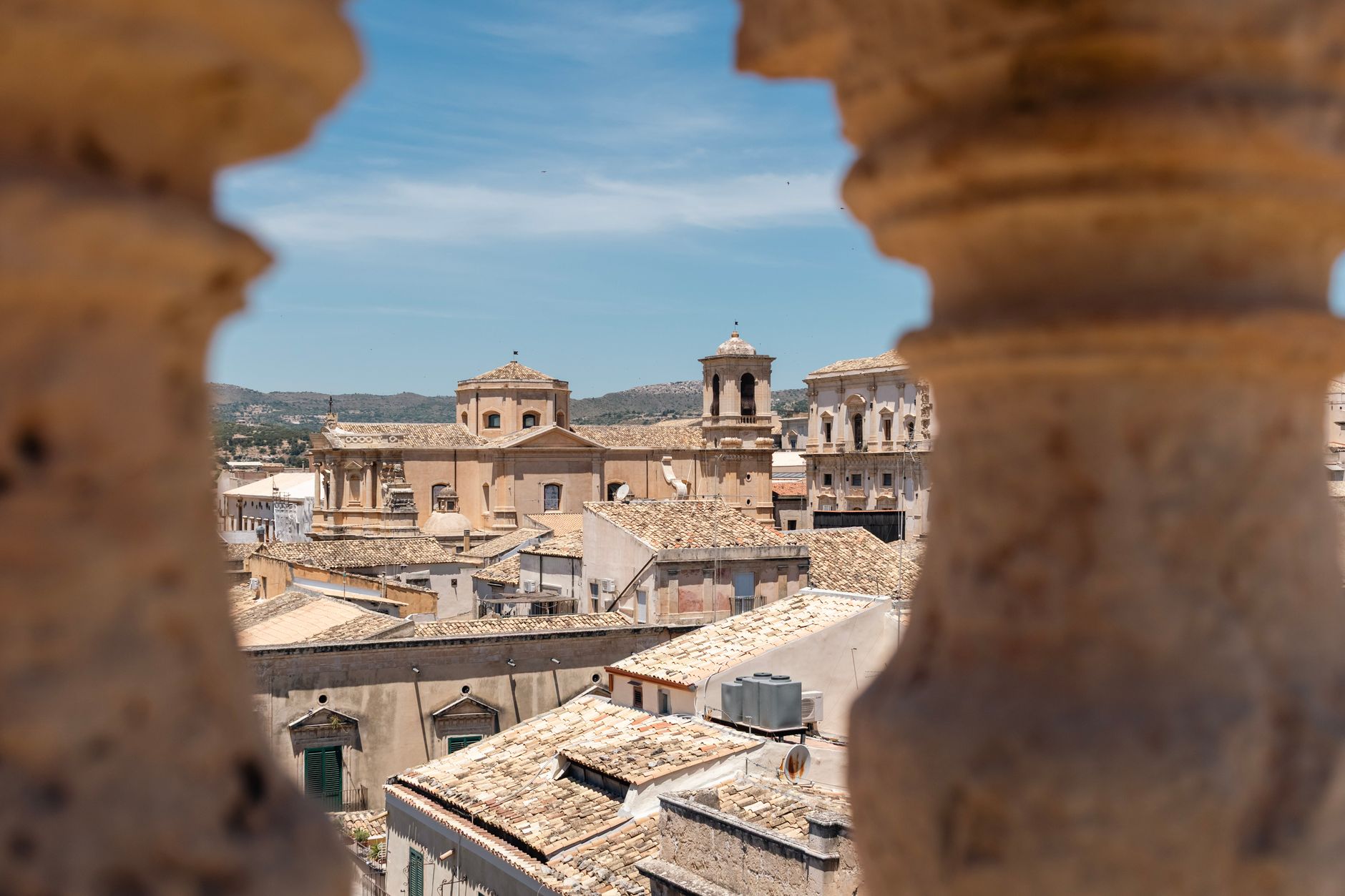 Sunlit Sicilian countryside with historic stone architecture, evoking early 20th century atmosphere