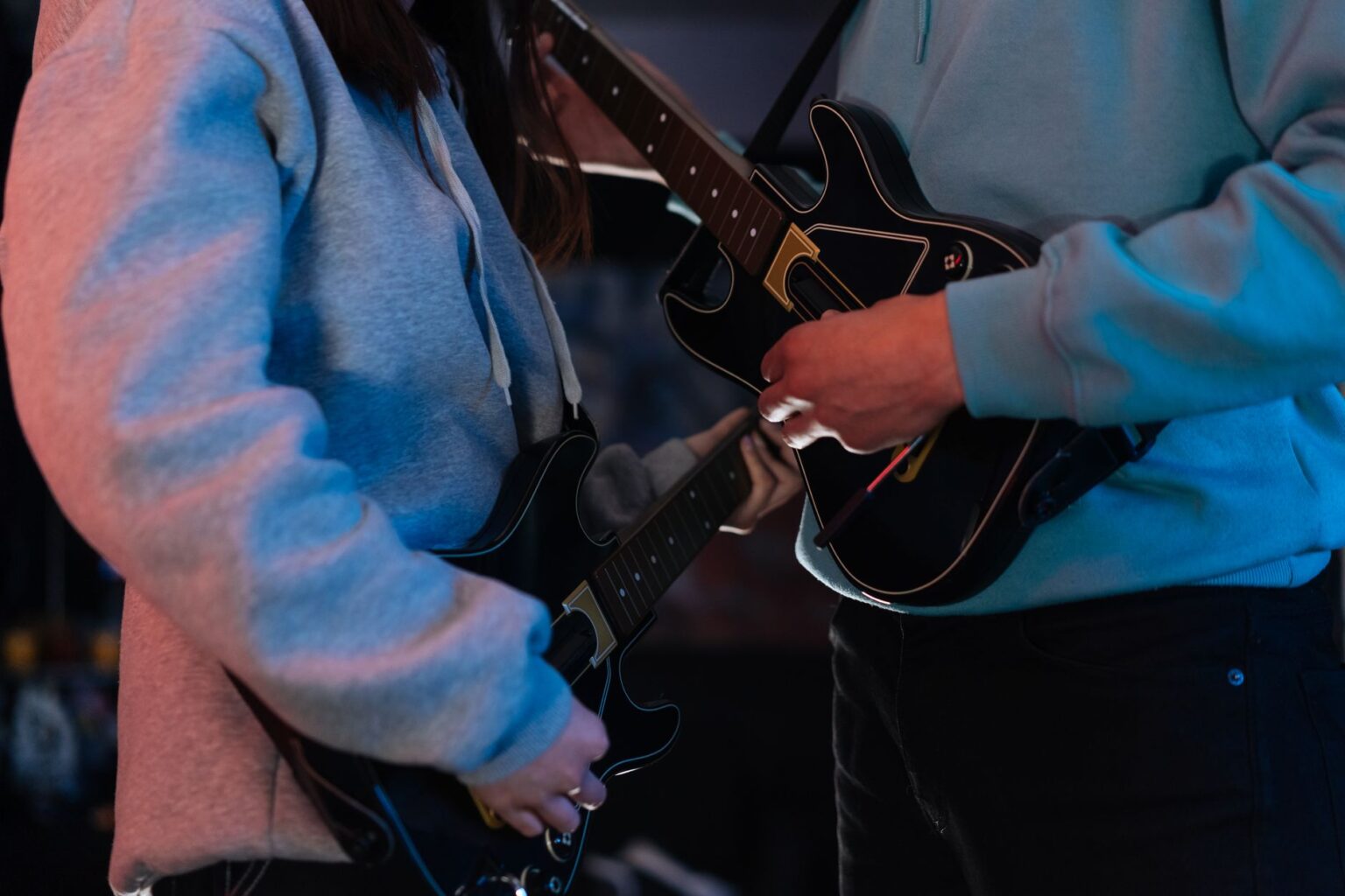 Activision’s Guitar Hero Silence Is Sending Fans Back to Clone Hero A colorful plastic guitar controller resting on a desk next to a gaming setup