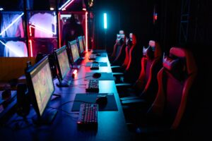 A gaming PC setup with glowing keyboard and monitor displaying a dark fantasy game interface