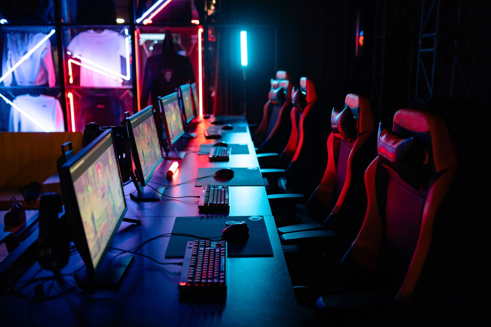 A gaming PC setup with glowing keyboard and monitor displaying a dark fantasy game interface
