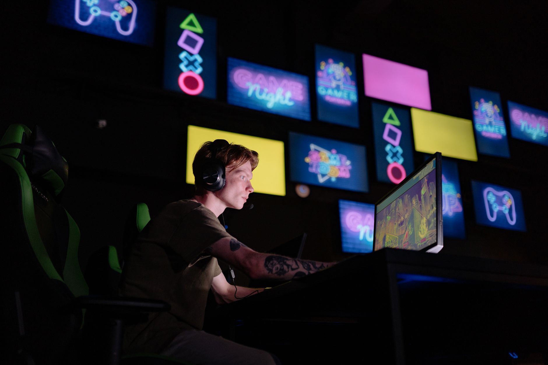 A gamer sitting in front of a monitor displaying a game loading screen