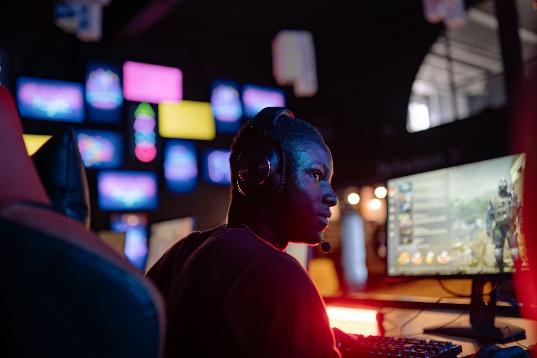 A player gaming at night in front of a glowing monitor screen