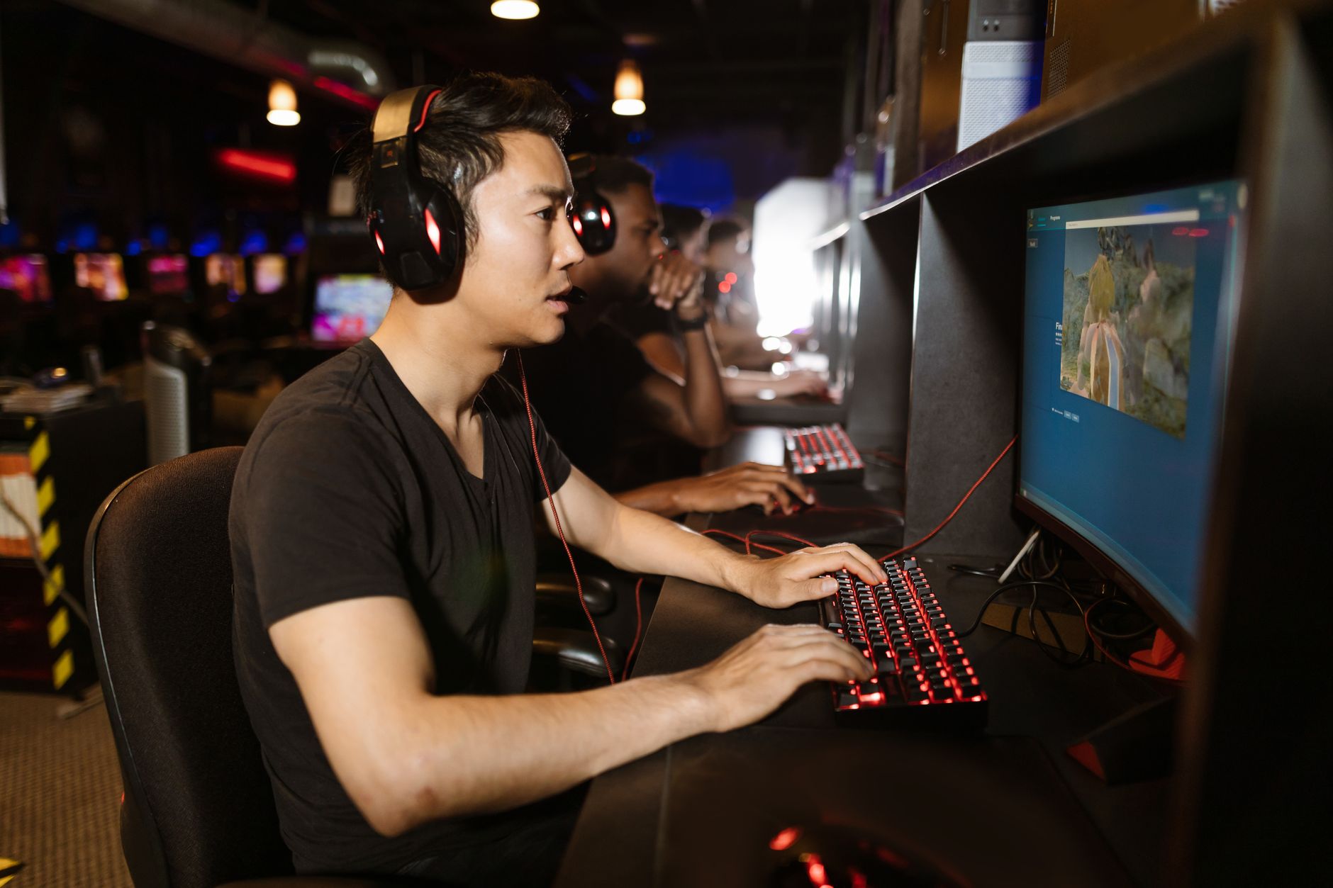 Person playing a video game with a glowing monitor in a dimly lit room